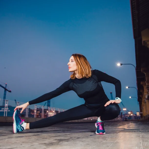 Kobieta rozgrzewa się na chodniku