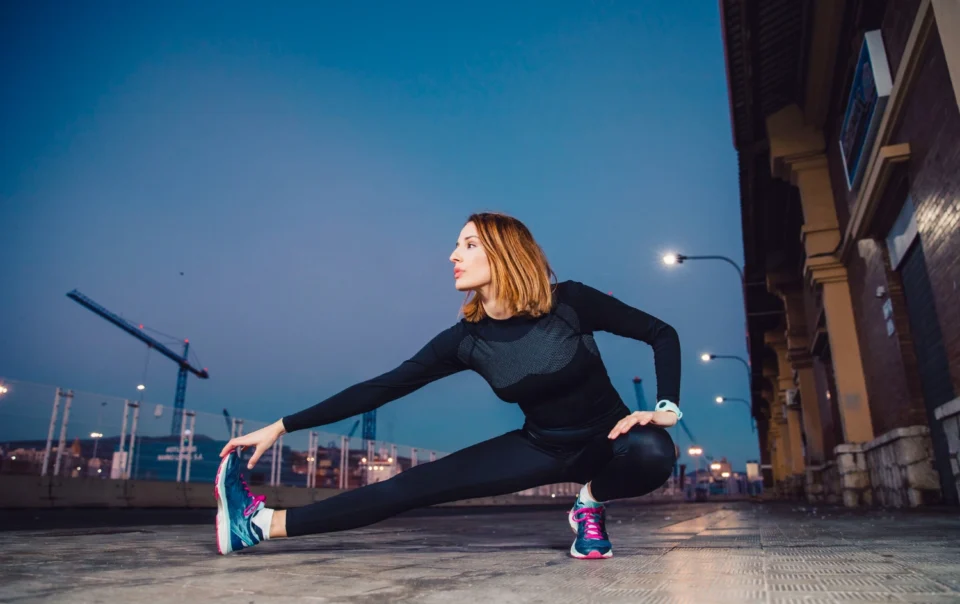 Kobieta rozgrzewa się na chodniku