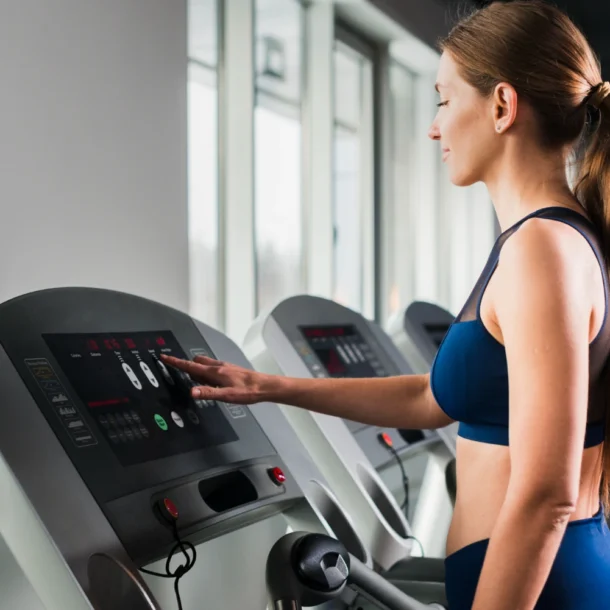 kobieta uruchamia bieżnie w fitness klubie